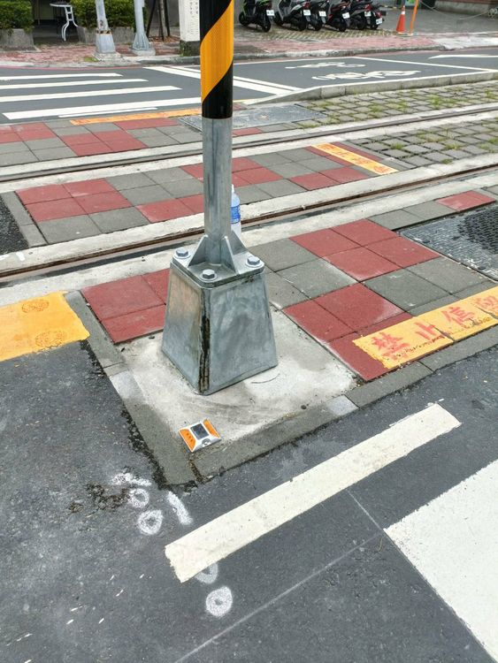 輕軌的號誌燈座遭汽車擦撞後裂開。讀者提供