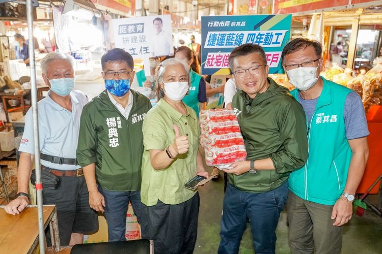 蔡其昌在市議員楊典忠(左二)與王立任(右一)陪同下走進海線梧棲市場，鄉親熱情致贈養樂多，預祝他年底選票多多。蔡其昌競總提供