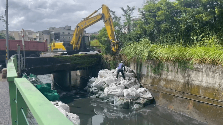 羅東十六份圳疏濬後污泥太空包堆放在圳溝，擔心颱風來襲影響水流，議員黃琤婷要求縣府水資處請包商於今天清理完畢。讀者提供