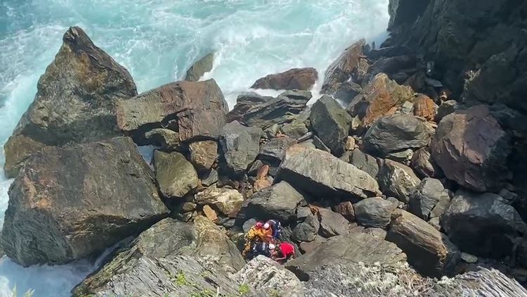 眾人合力將受傷婦人搬運至空曠處由直升機送醫。讀者提供