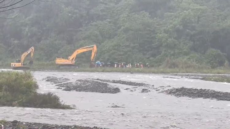 天色漸暗，擔心山區雨勢再起危及受困民眾安全，警消緊急以2部怪手接力將受困民眾運出。讀者提供
