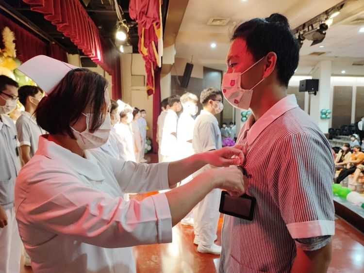 師長為男學生別上名牌。王志弘攝