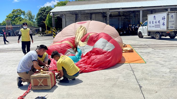 天際航空的熱氣球飛行員及地勤人員數人，共同操作熱氣球立球。古和純攝