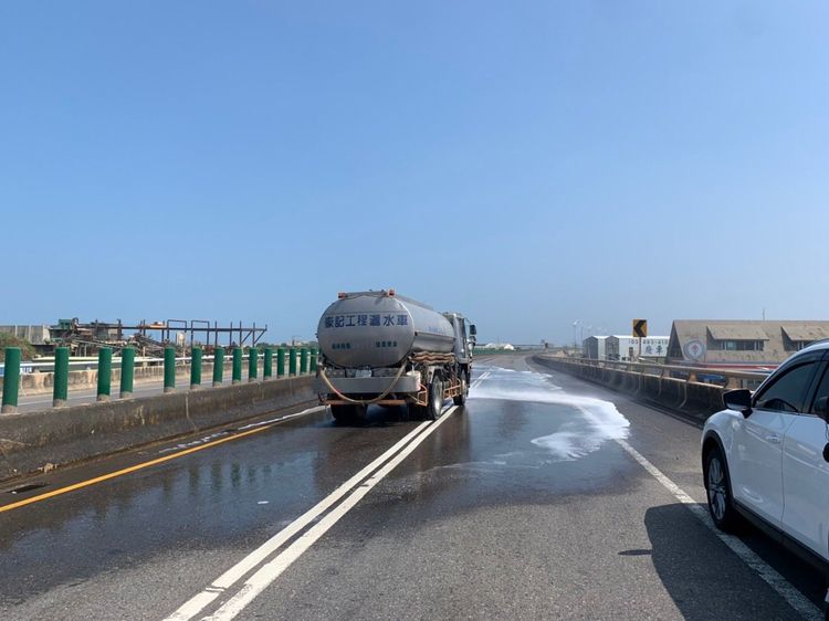 現場灑水清除強鹼化學液。桃園市消防局提供