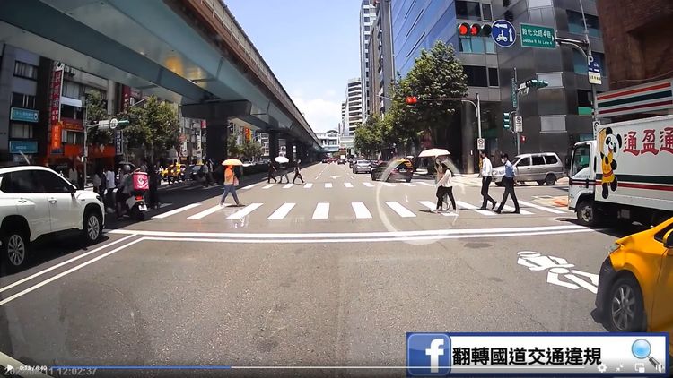 騎機車的外送員闖紅燈後，還在斑馬線上與行人爭道。翻攝自臉書「翻轉國道交通違規」