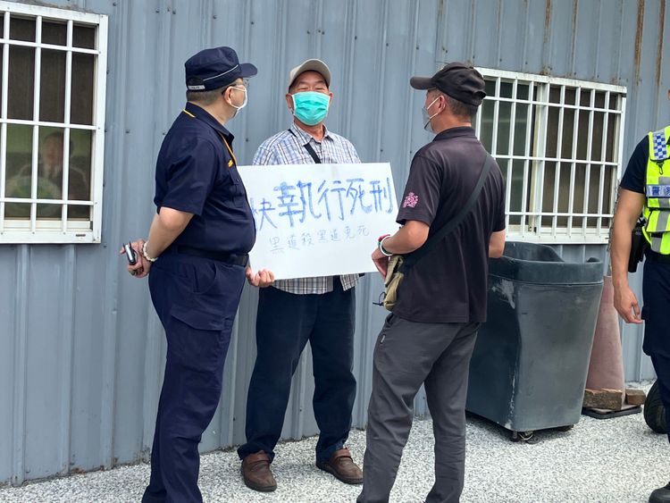 有男子在會場外持快執行死刑標語陳情遭勸離。民眾提供