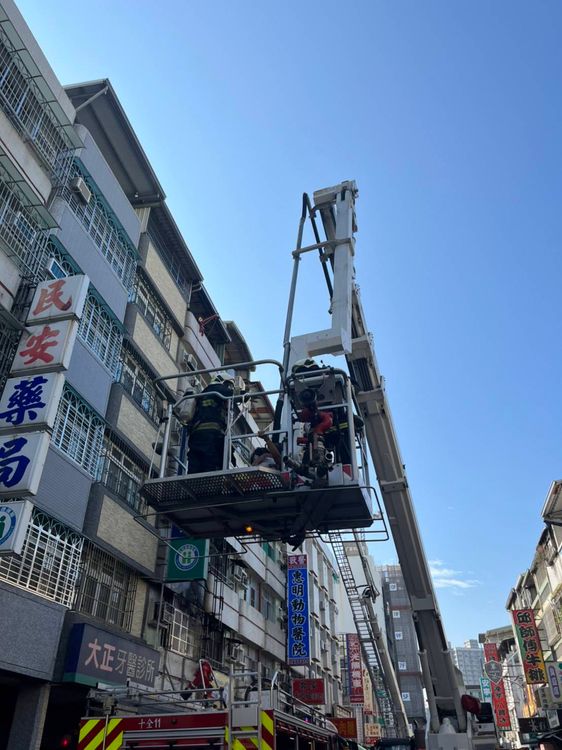 消防人員用雲梯車救出王姓男子一家三口。讀者提供