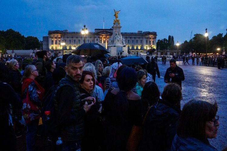 白金漢宮13日晚間守候迎接女王靈車的大批人潮。美聯社