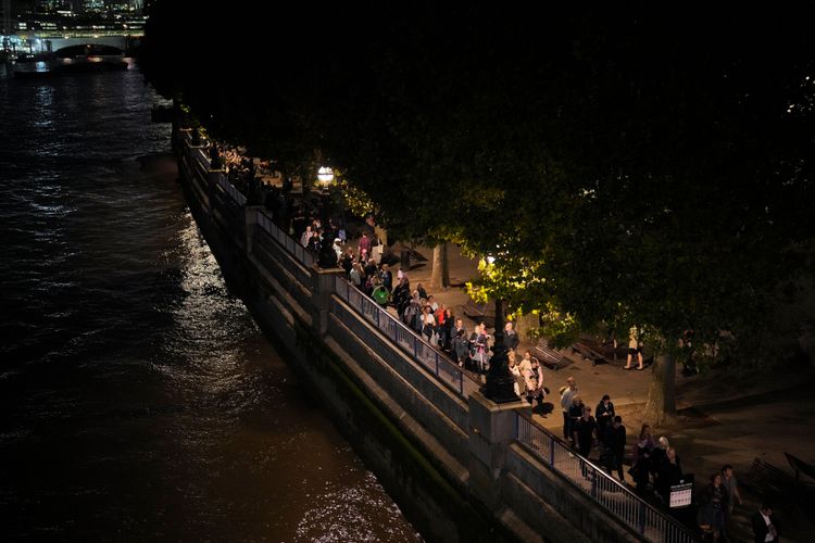即使在晚間，泰晤士河邊排隊的人潮依然不減。美聯社