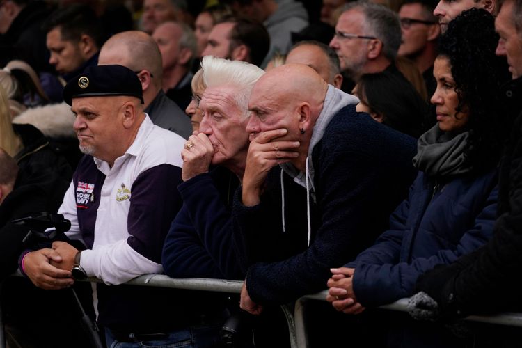 女王國葬儀式在西敏寺舉行，許多民眾站在街上聆聽直播，神情嚴肅。美聯社