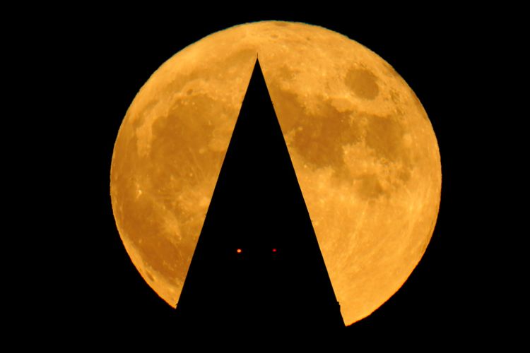 美國華府的滿月，華盛頓紀念碑頂的兩個紅色亮點是對飛機的警示燈。美聯社