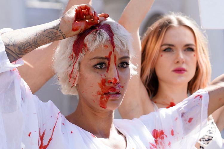 伊朗裔藝術家在臉上和身上潑灑假血，抗議當局血腥鎮壓伊朗示威者。美聯社