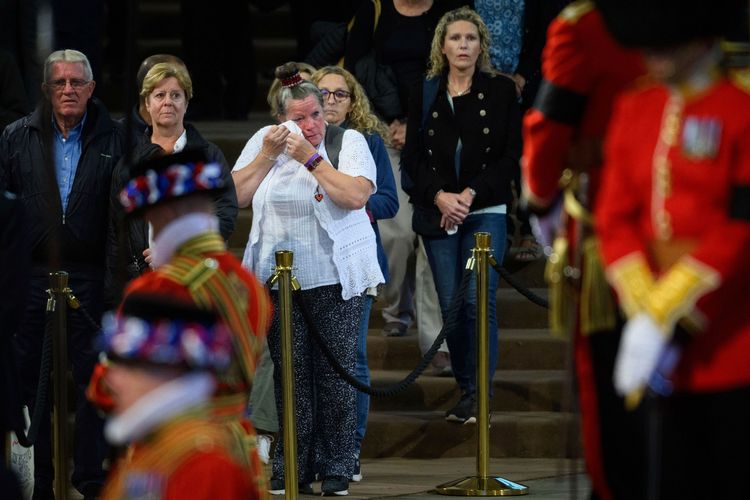 進入西敏廳瞻仰女王靈柩的民眾傷心拭淚。路透社