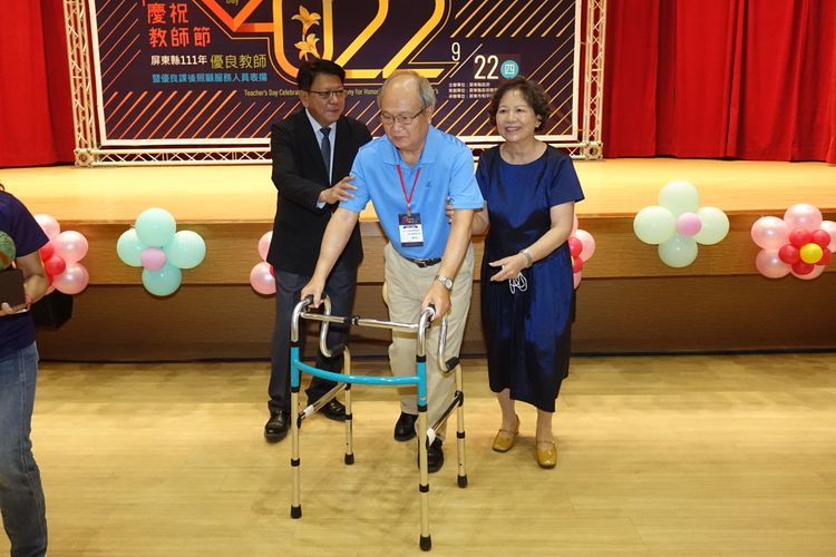 屏東高中退休的曾彩金老師獲得教育奉獻獎，因為行動不便，縣長潘孟安貼心走下台頒獎。羅琦文攝