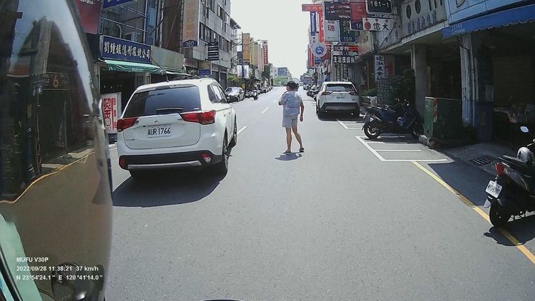 婦人也因為駕駛按喇叭，被嚇得往後退。讀者提供