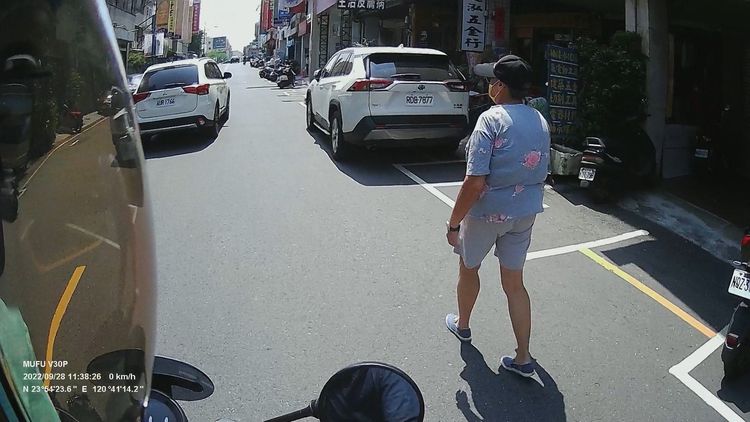 事後婦人仍裝沒事，繼續自顧自的行走路邊，並未再危險穿越。讀者提供