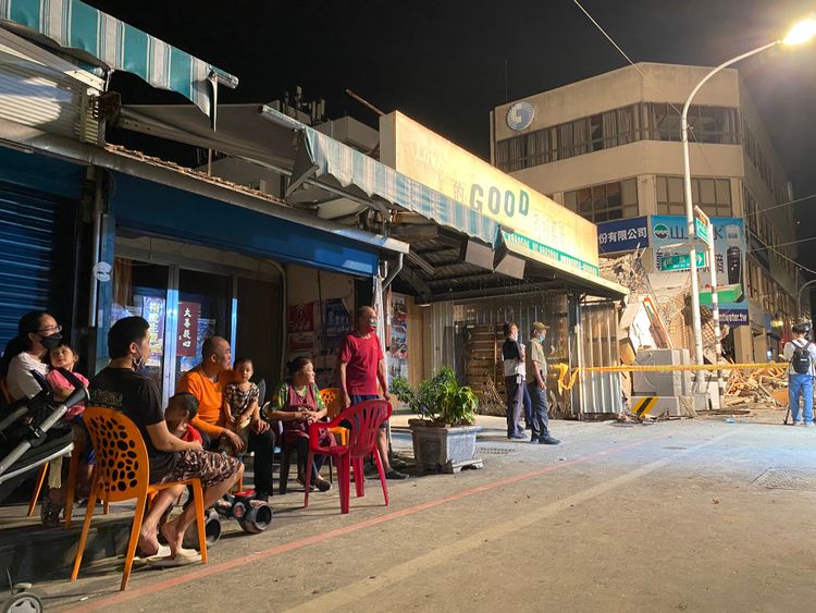 當地居民無電可用，只好待在屋外看著倒塌大樓拆除。陳明中攝