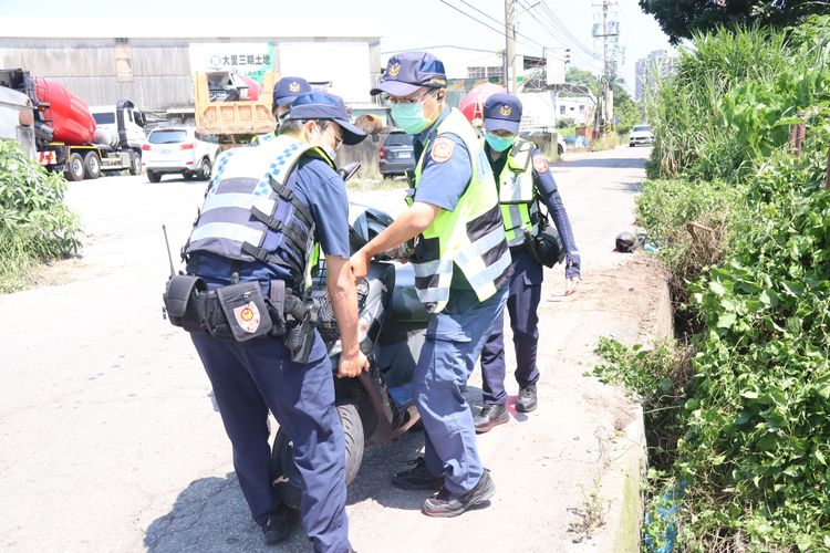 警員徒手將機車移置安全處。張喆喜攝