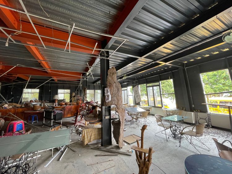 入口右側望去原本是自住吧用餐區，同樣滿地碎裂的餐盤以及遭到天花板掉落物砸毀的課桌椅，大約一名成年人的頭頂高度就能看到落露的電線，場面令人怵目驚心。彭欣偉攝