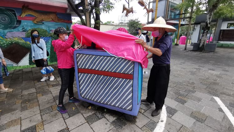 工作人員替幾米廣場的裝置藝術覆蓋帆布防颱。林泊志攝