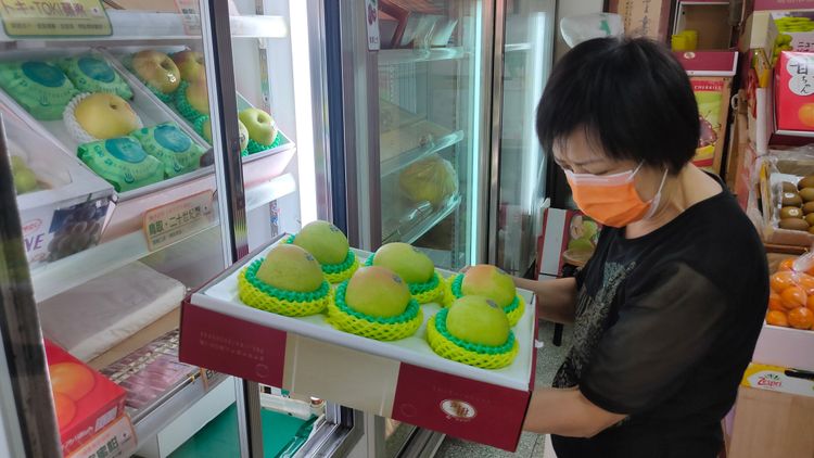 老闆娘蔡素貞望著手中的蘋果禮盒，不捨說「這些賣完就停業了」。鮮明攝