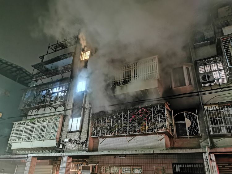 民宅前方竄出濃煙，後側則竄出火光。陸運鋒攝