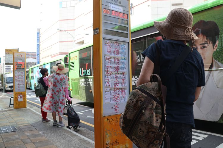 民眾停下腳步看招牌寫了些什麼內容。張喆喜攝