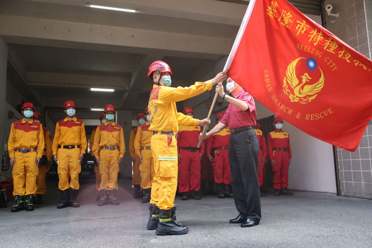 消防局長陳龍輝(紅衣)授旗給演練指揮官。戴之聖攝