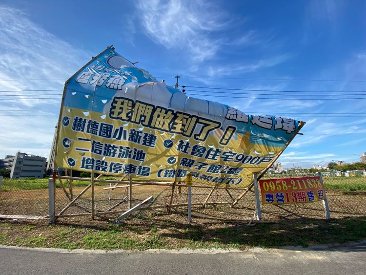 看板上的市長和議員快被強風吹跑。張喆喜攝