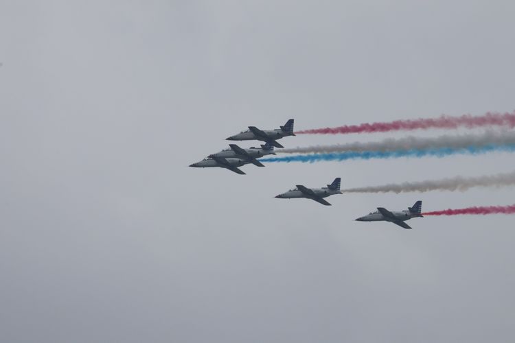 空軍雷虎小組AT-3教練機編隊飛越觀禮台，留下象徵國旗顏色的彩煙。彭欣偉攝