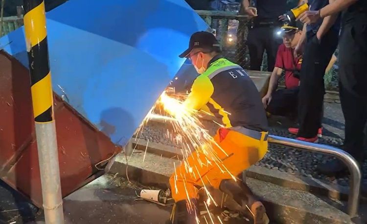 警消利用切割器破壞鎖頭。讀者提供