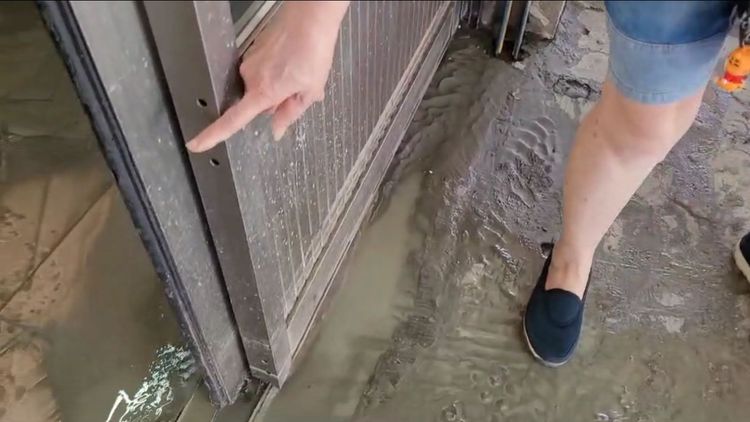 店家指著淹水最高位置，大約是成人的膝蓋高度。民眾提供