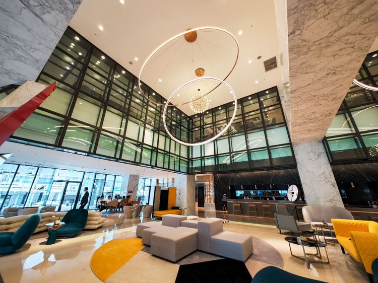 剛走入挑高大廳，上方可見天花板圓形裝飾燈。田欣雲攝