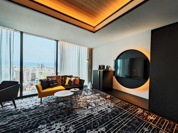 房內圓形休息椅、圓形電視牆造型背板、圓形客廳茶几、閱讀燈、檯燈，都延續圓形設計。田欣雲攝