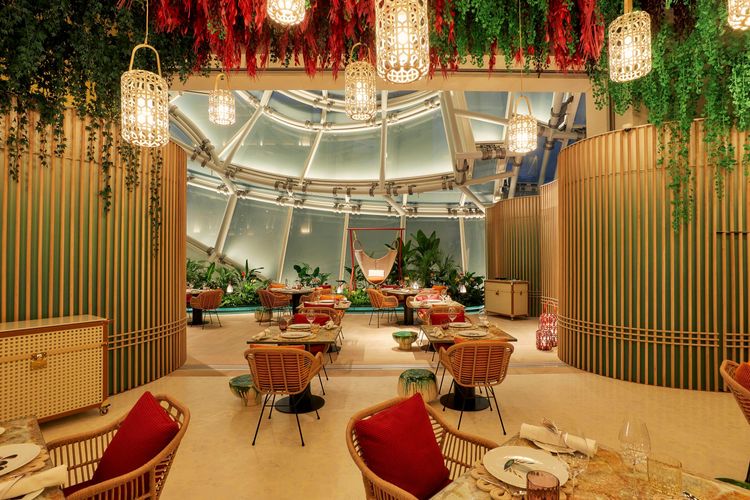 Alain Passard at Louis Vuitton餐廳就著獨特圓弧形透明玻璃窗戶的採光空間，以花園為主題設計，創造了充滿天光、綠色植物與獨特風格桌椅、燈飾組成的自然氣息空間。品牌提供