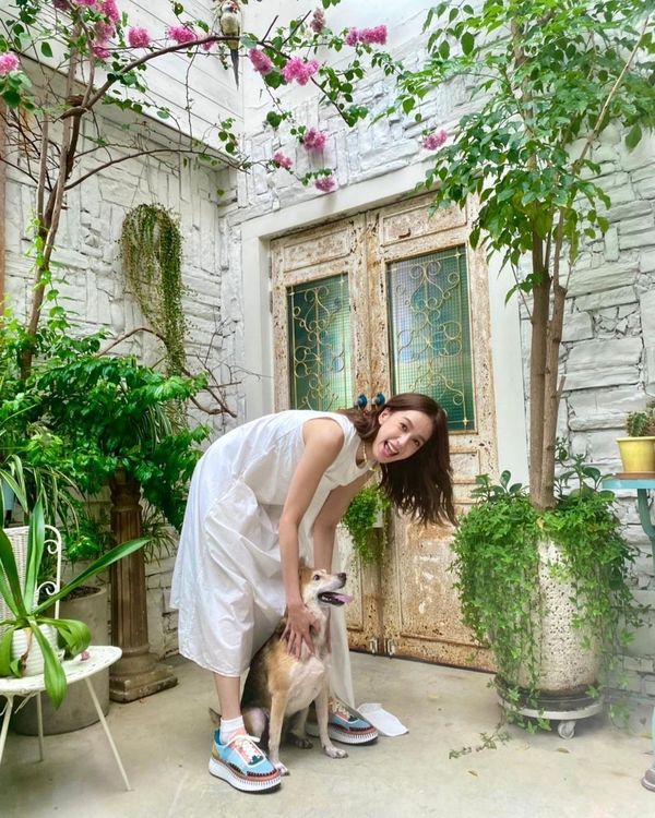 穿上白洋裝的陳庭妮配搭了Chloé新色花草綠Nama運動休閒鞋，跟愛犬阿喜一同入鏡，閃燦著輕鬆愉快的笑容。 翻攝chen_ting_ni IG