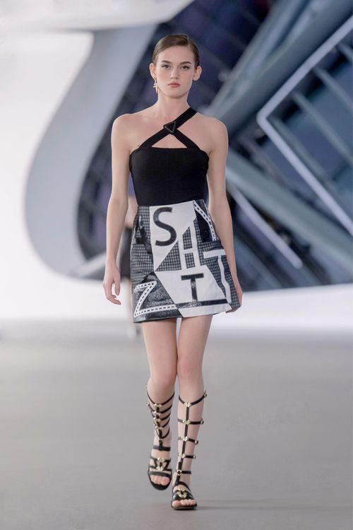 肩帶線條交錯出稜角形狀的立體剪裁背心搭配 SHIATZY字體錯位拼接膝上裙。品牌提供