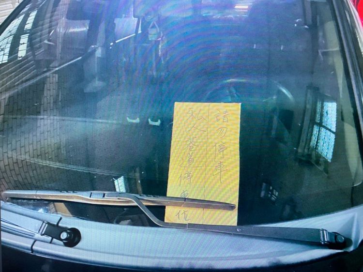 紙張上頭寫著私人巷道停車位，請勿停車。讀者提供