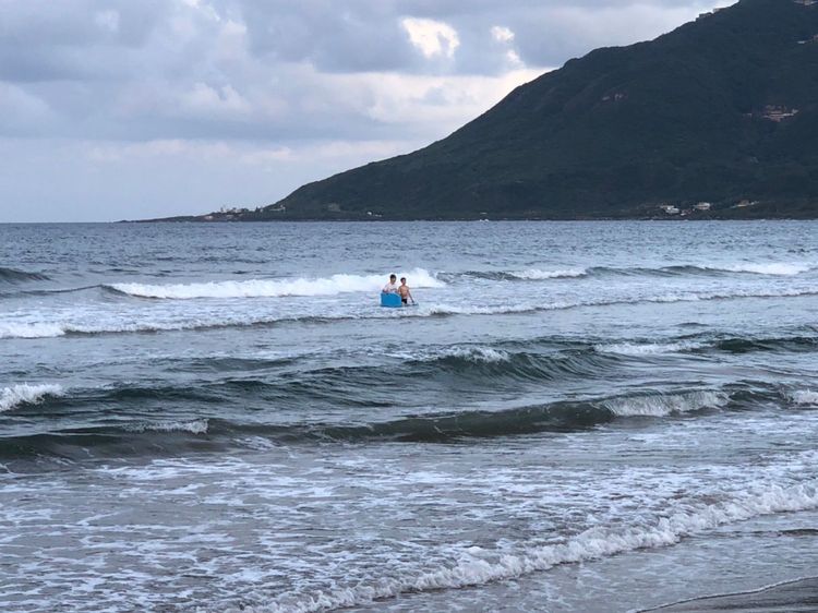 兄妹在貢寮龍門沙灘玩浮板戲水。讀者提供