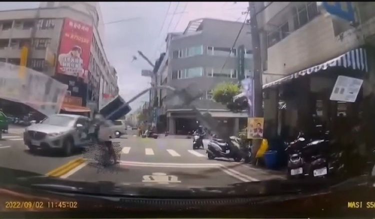 交通號誌燈倒下直接命中等待紅綠燈的女騎士。讀者提供