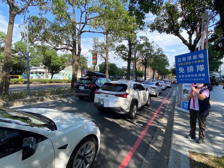 雙十連假交通局推出市政地下停車場消費享停車優惠，還派人持手卡提醒排隊車流。交通局提供
