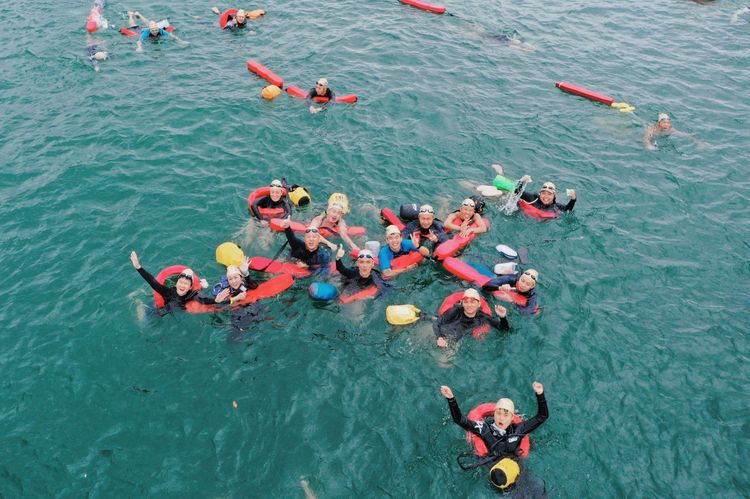 參加泳客在大雨中泳渡日月潭十分興奮，尖叫聲歡呼聲此起彼落。南投縣府提供