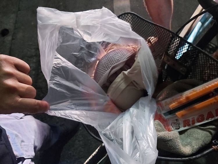 石姓男子把偷來的女用內衣褲裝在塑膠袋，放在腳踏車前置物籃。讀者提供