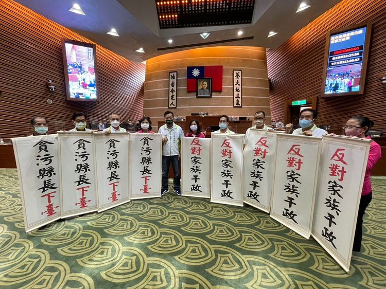 民進黨宜蘭縣議會黨團趁林姿妙在議會上台致詞時突襲，高舉「貪污縣長下臺」、「反對家族干政」捲軸，批林姿妙不適任。民進黨宜蘭縣黨部提供