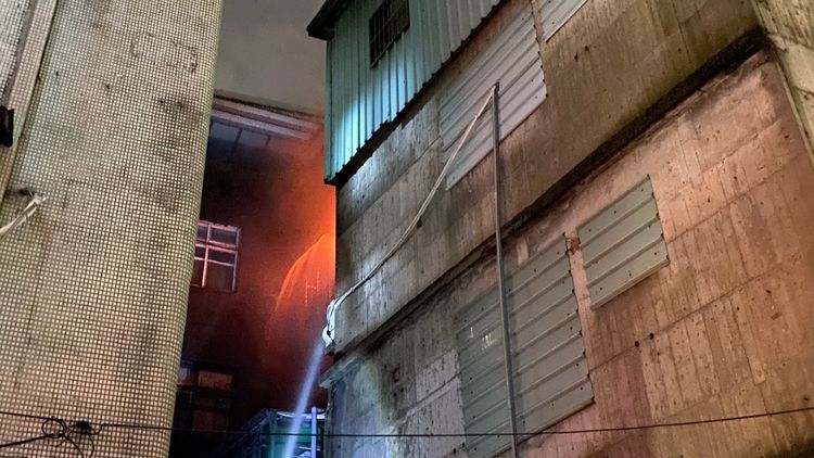 火煙從公寓4樓竄出，消防人員灌救。民眾提供