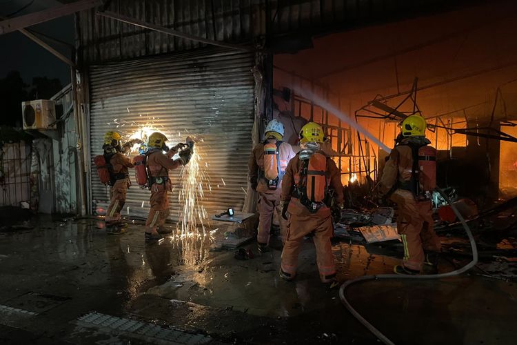 消防人員鋸開鐵捲門入內灌救。屏東縣消防局提供