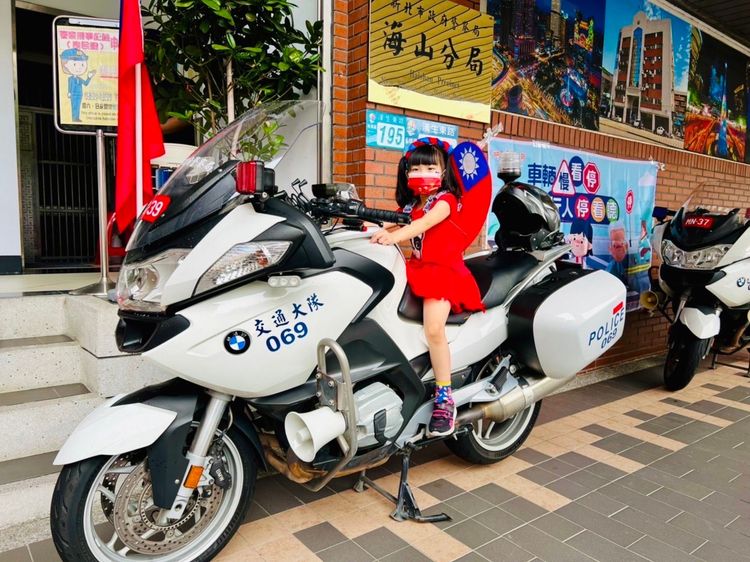 小小朋友穿著國旗裝興奮地坐上警用重機。警方提供