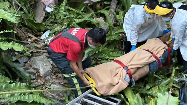 救護人員協助將駕駛扛上路面。讀者提供