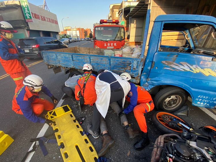 徐姓騎士撞上貨車後，人一度卡在車底，救護人員迅速救出送醫。民眾提供