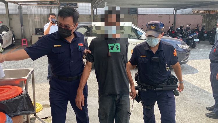 警方帶回涉嫌割破宣傳旗幟的顏男（中）送辧。讀者提供